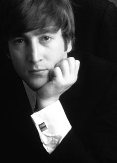 black and white photograph of a young man with his hand on his chin looking at the camera