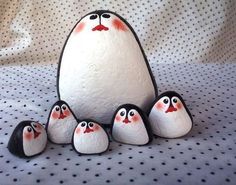 a group of penguins sitting next to each other on top of a white sheet with polka dots