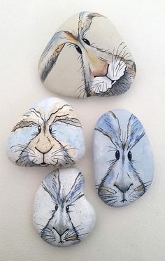 three painted rocks with faces of animals on them