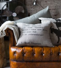 two pillows sitting on top of a brown leather chair