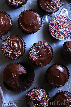 cupcakes with chocolate frosting and sprinkles are on a table