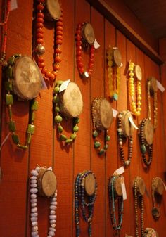 a wall covered with lots of different types of beads and necklaces hanging on it's sides