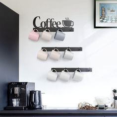 coffee cups are hanging on the wall above a counter