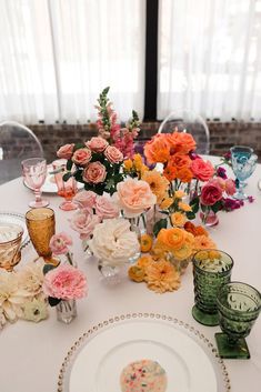 a table topped with lots of different types of flowers and vases next to each other