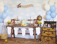 a baby shower is set up with balloons and pictures on the table for guests to eat