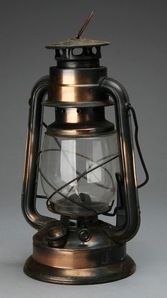 an old fashioned metal lantern with glass inside