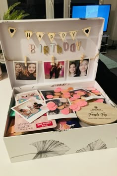 an open birthday box with photos and decorations