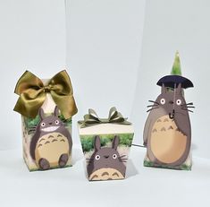 three small boxes decorated with totoro and a gift box wrapped in gold ribbon