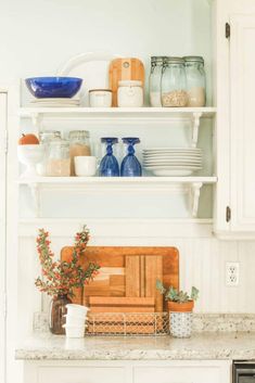 the shelves in the kitchen are filled with dishes