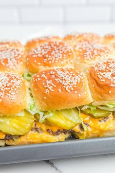 a tray filled with sandwiches covered in cheese and lettuce