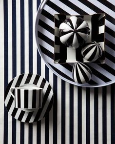 black and white striped table cloth with plates, cupcakes and napkins on it