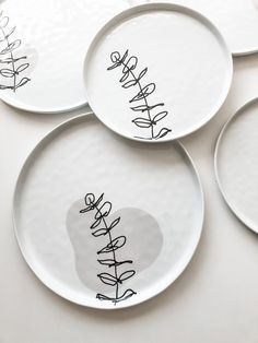 four white plates with black writing on them