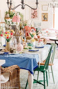 a dining room table is set with plates and vases