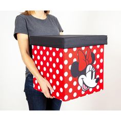 a woman holding a red and white box with minnie mouse on it's side