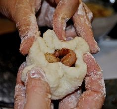 two hands are holding dough and kneading it