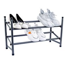 two pairs of shoes are sitting on a shoe rack that holds three pairs of shoes