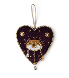 a heart shaped ornament with an eye and chain hanging from it's side