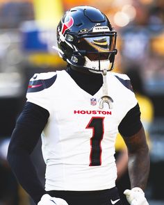 a close up of a football player wearing a uniform and holding his hands behind his back