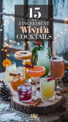 an assortment of winter cocktails on a wooden table with pine cones and lights in the background