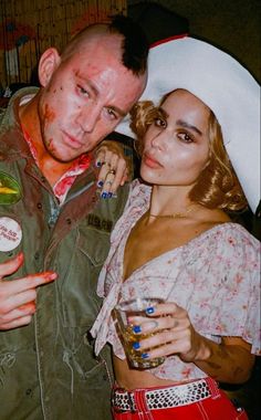 a man and woman are dressed up as zombies for the halloween party, one is holding a drink in her hand