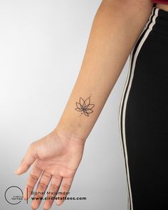 a woman's hand with a small tattoo on her left arm and the wrist