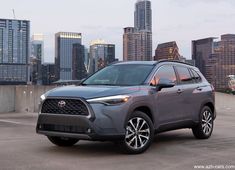 a gray toyota rav parked in front of a city skyline