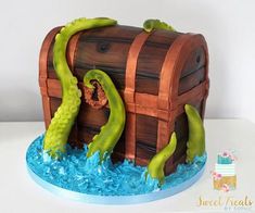 there is a cake that looks like a pirate's chest with green tentacles coming out of it