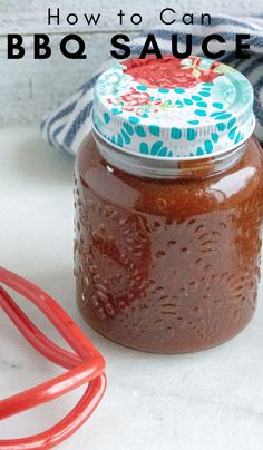 how to can bbq sauce in a glass jar with red tongs next to it