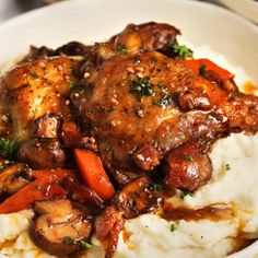 a white plate topped with mashed potatoes and meat