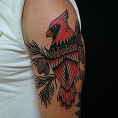 a man with a red bird on his arm and pine cones around the arm area