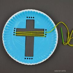 a paper plate with a cross on it and some yellow string attached to the side