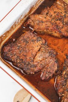 three pieces of meat in a pan with sauce