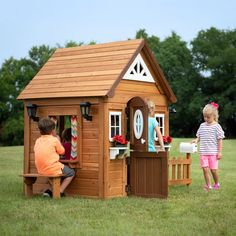 two children playing in a wooden play house