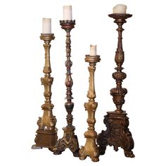 three tall wooden candlesticks sitting next to each other