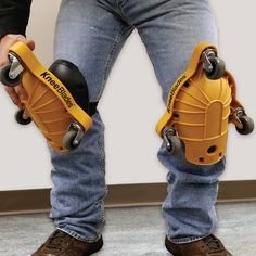 a man holding two yellow skateboards in one hand and another with wheels on the other