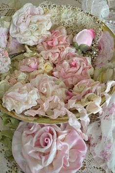 there are many pink flowers in the bowl on the lace tablecloths and doily