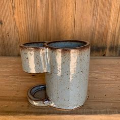 two coffee mugs sitting on top of a wooden table