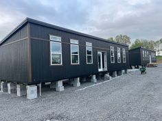 a couple of tiny houses sitting on top of gravel covered ground next to each other