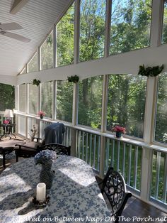 an enclosed porch with tables and chairs