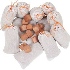 several bags filled with wooden blocks on top of a white table cloth covered in orange string