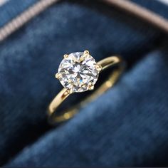 an engagement ring in a velvet box with the diamond on it's center stone