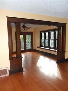 an empty living room with wood floors and windows