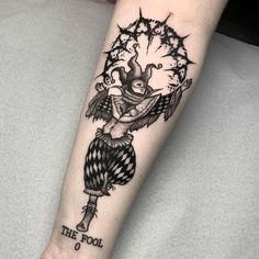 a black and white tattoo with an evil clown on it's arm that says, the fool