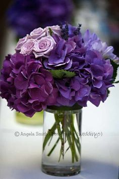 purple flowers in a glass vase on a table