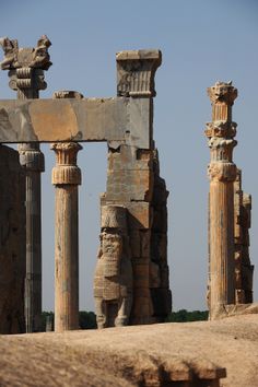 an ancient building with columns and statues in the foreground