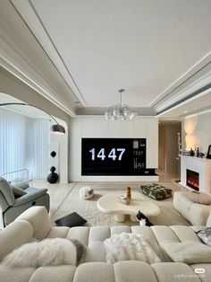 a living room with white furniture and a large clock on the wall