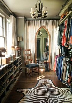 a closet with zebra print rugs and clothes hanging on the wall next to it