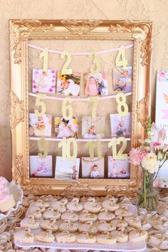 a table topped with lots of cookies and cupcakes next to a framed photo