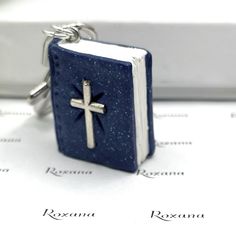 a blue book with a silver cross on it sitting on top of a sheet of paper