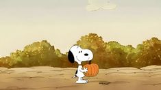 a cartoon dog holding a pumpkin in the middle of a dirt field with trees behind it